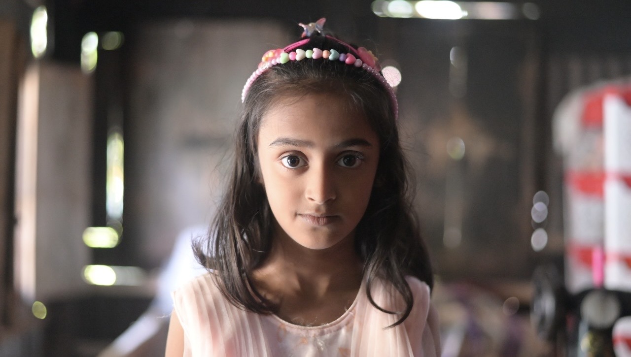Girl with a beaded headband looking at the camera